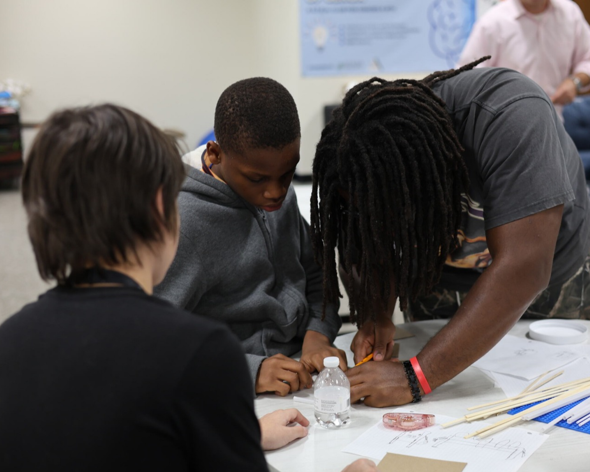 Students gathered around a table working on a table prototype